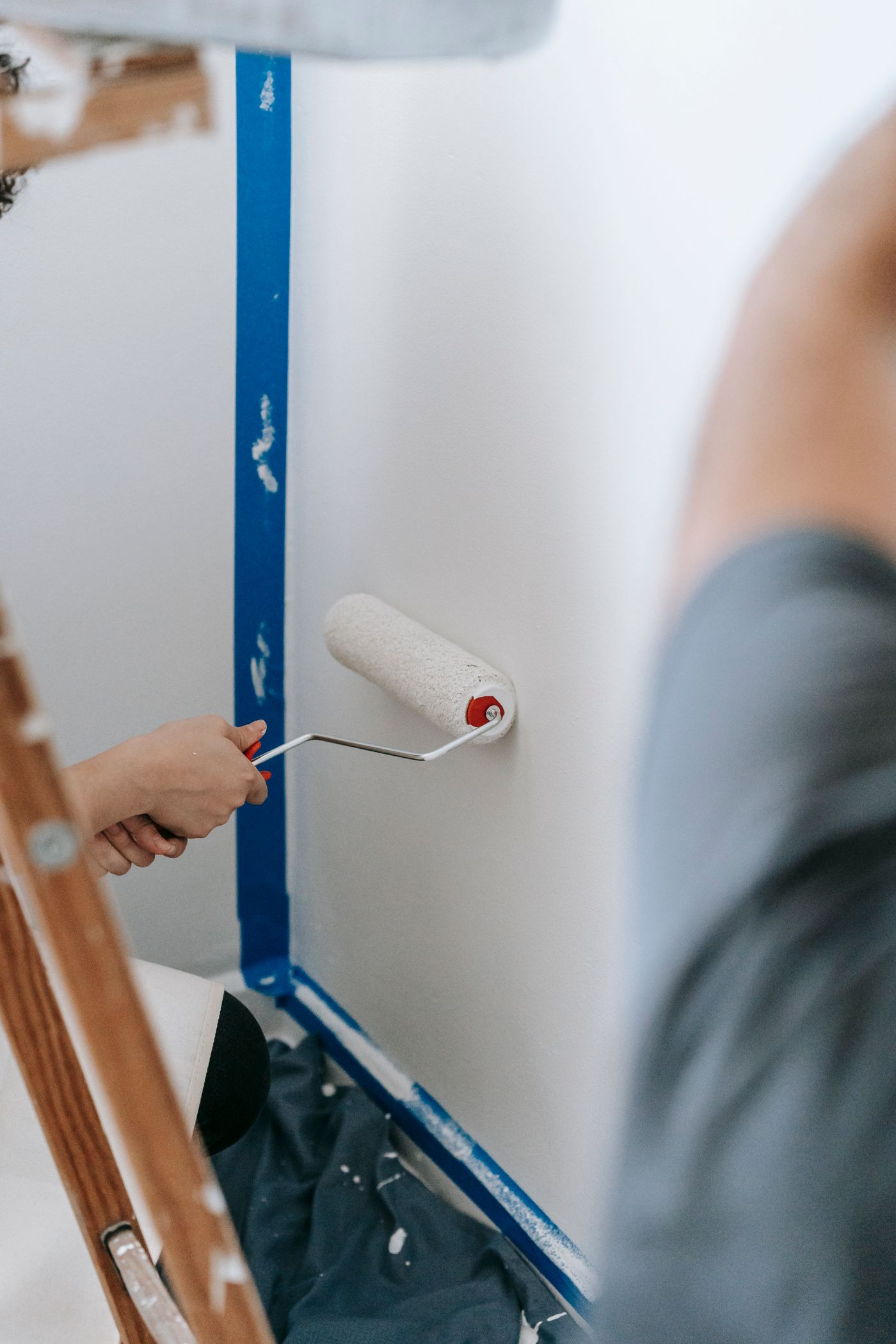 Representative stock photo of people painting an interior room with rollers